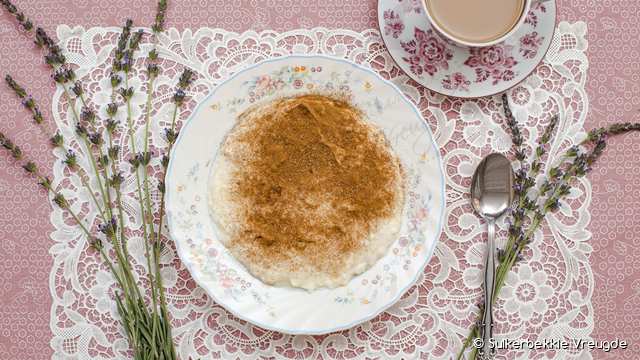 Melkkos en 'n koppie koffie op 'n kantdoek met laventel
